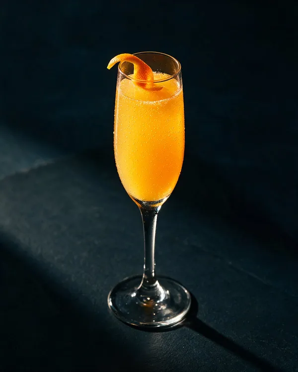 Orange Mimosa i flöjtglas med små bubblor och ett tunt apelsinzest