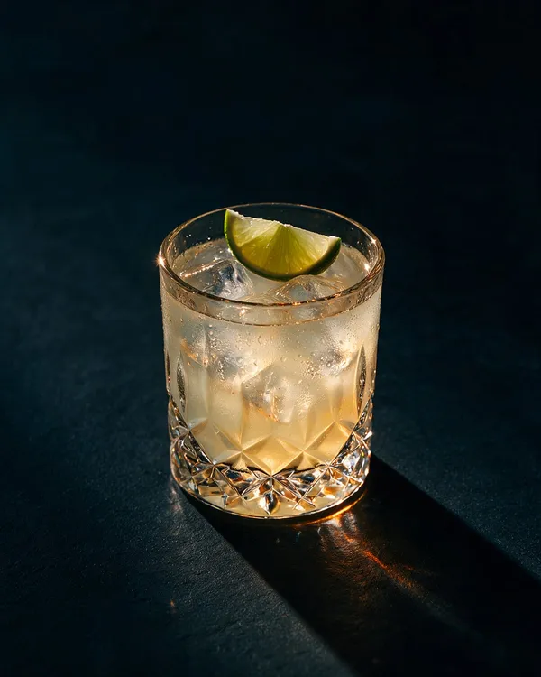 Ljusgul Tommy's Margarita i rocksglas med is och limeklyfta